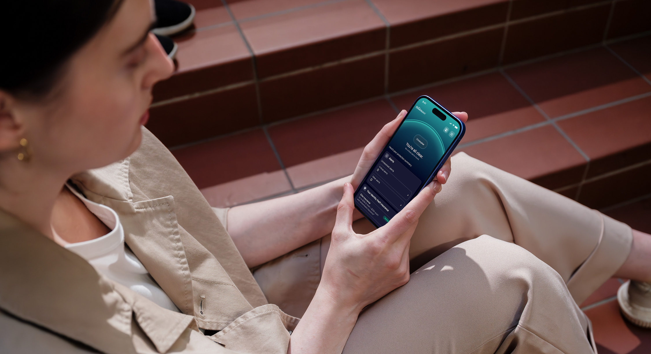 Person sitting on outdoor steps looking at a phone