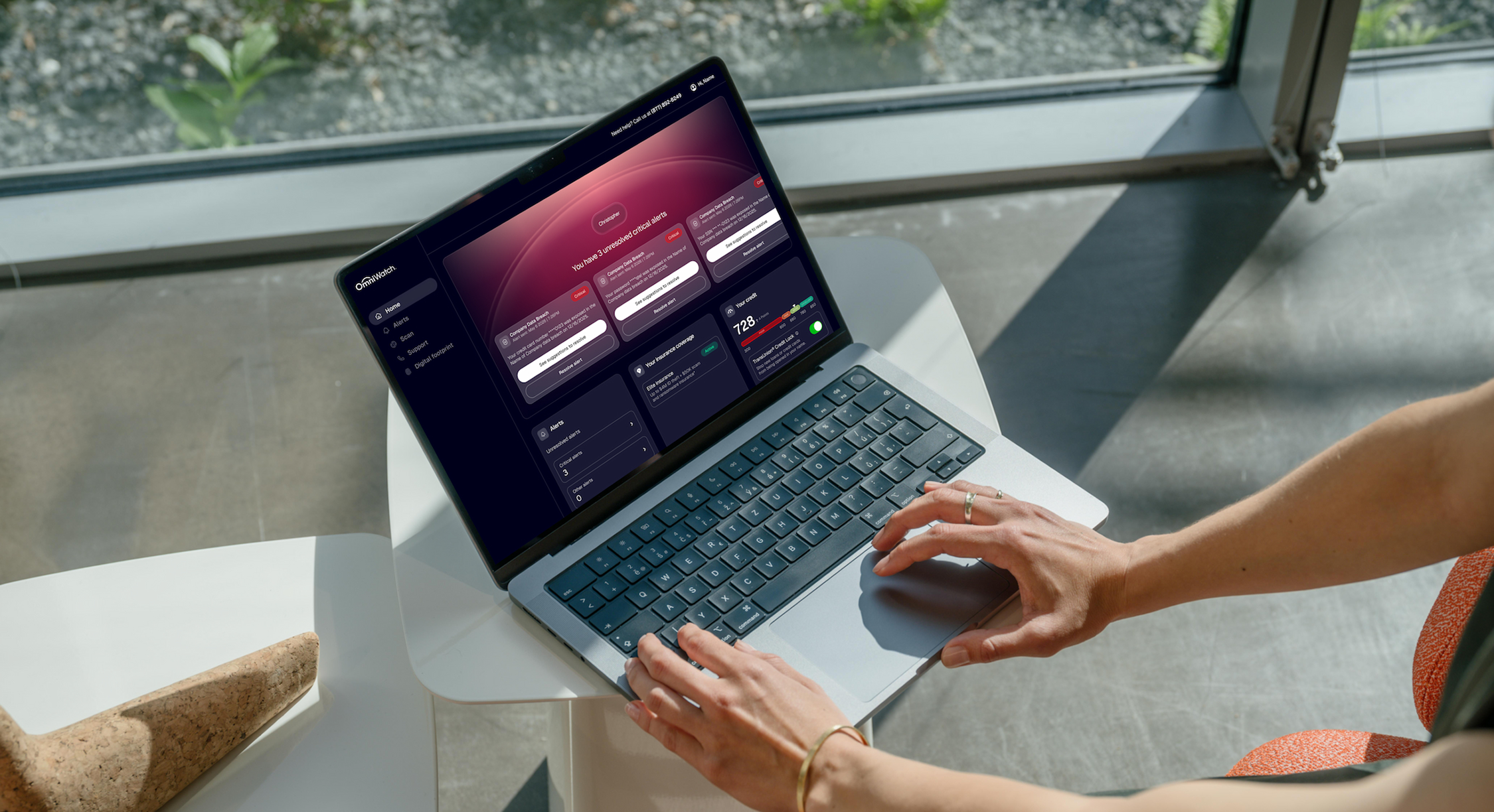 OmniWatch web dashboard on a laptop with unresolved critical alerts