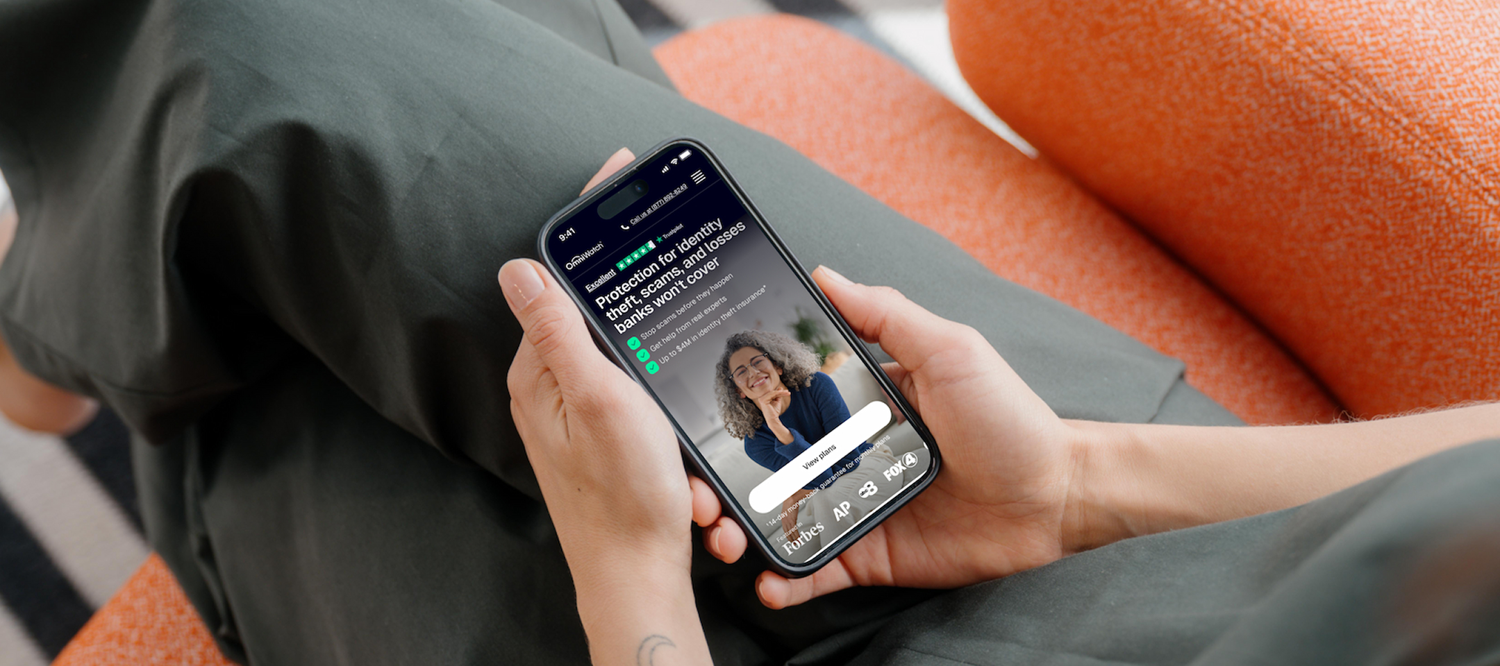 Hands holding a phone showing the OmniWatch website